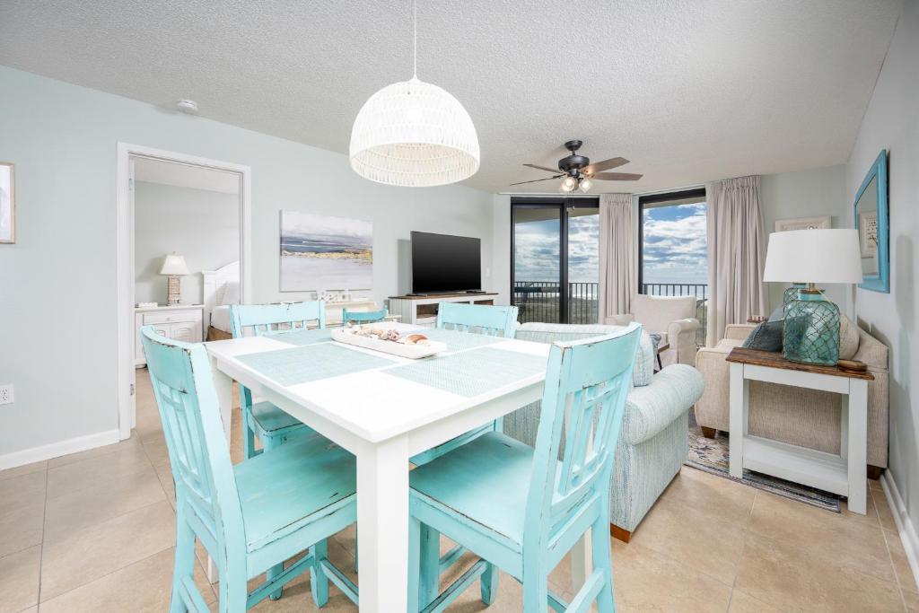 a dining room and living room with a white table and chairs at Phoenix VI 6312 in Orange Beach