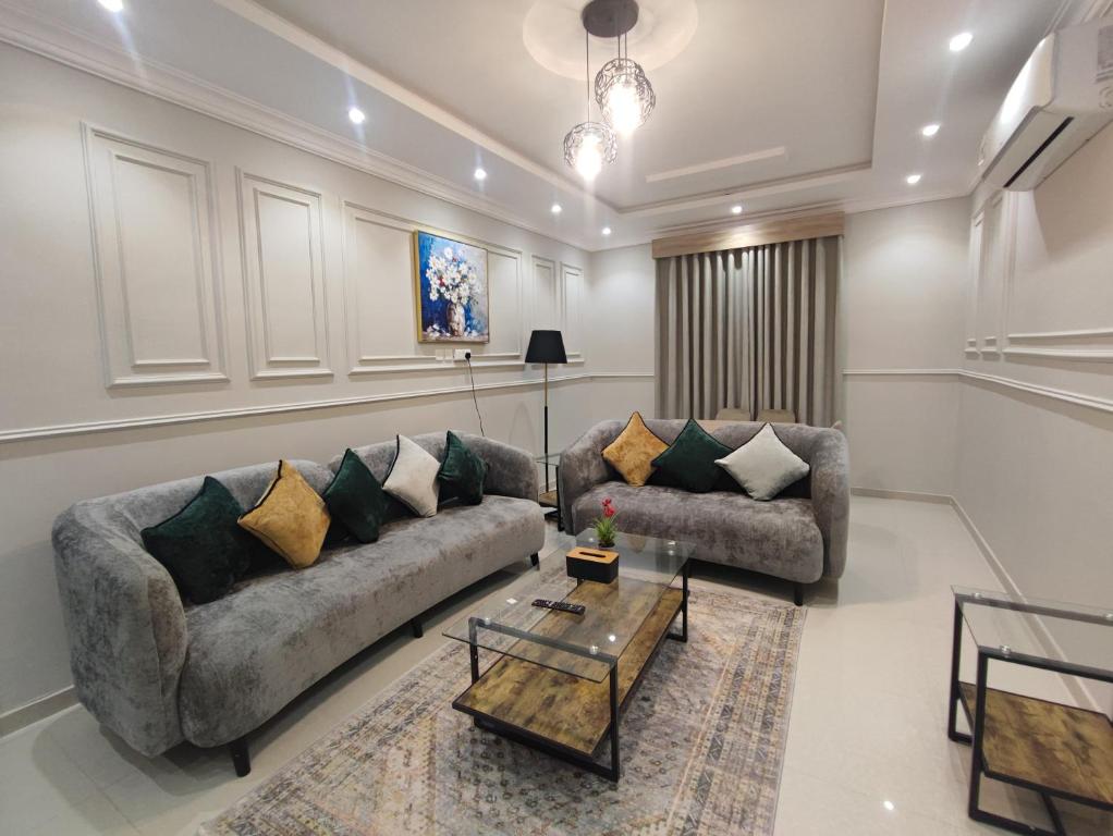 a living room with two couches and a coffee table at اجنحة مأرز الايمان in Medina