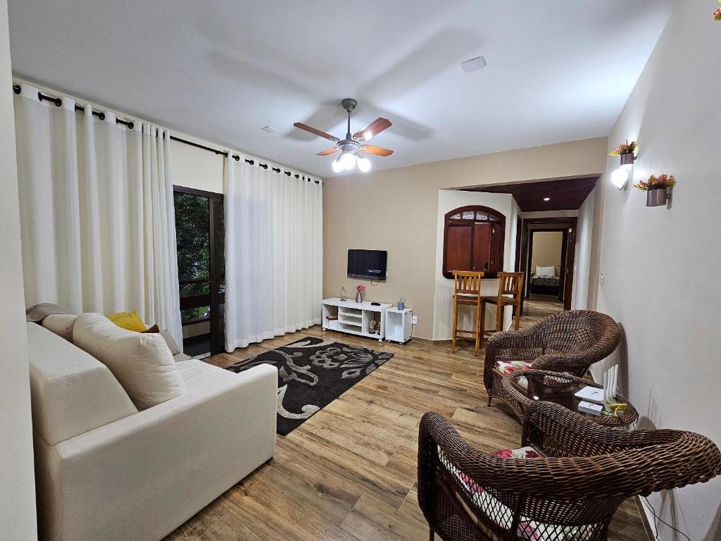 a living room with a white couch and chairs at Piemont Flat Apart in Serra Negra