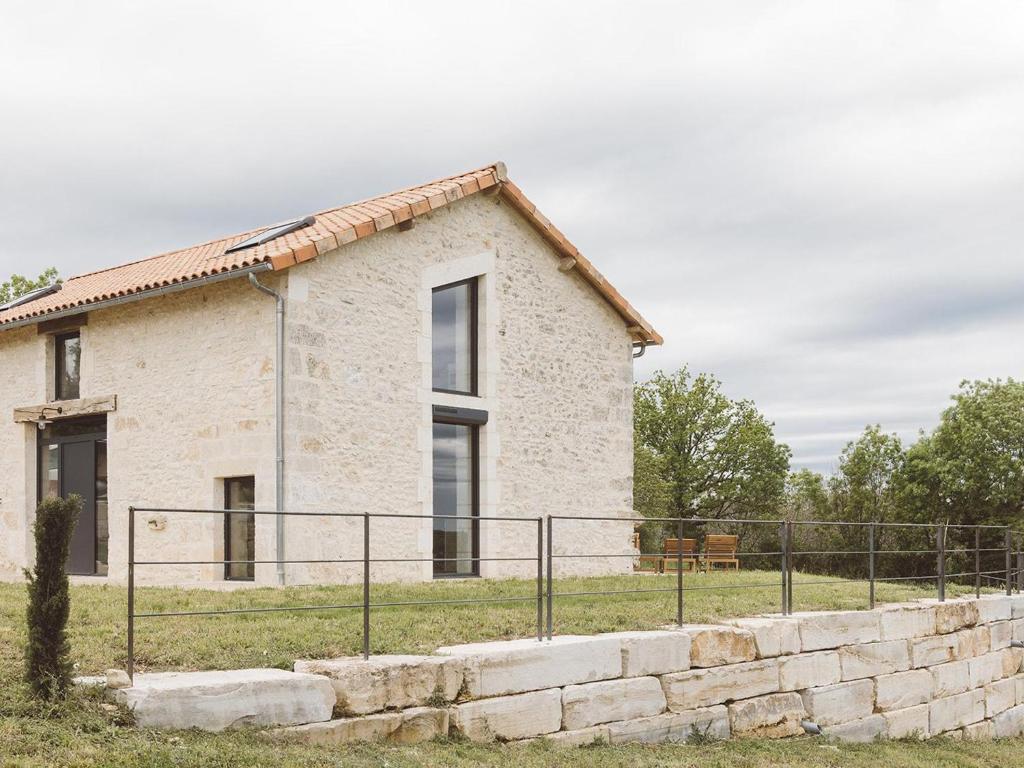 a stone house with a fence in front of it at Maison climatisée avec terrasse et Wi-Fi, animaux admis, proche Périgord Vert - FR-1-616-391 in Sorges