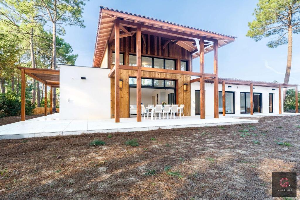 une maison dans les bois avec un pavillon dans l'établissement Biscarrosse Lac Villa de charme PMR climatisée avec vue sur le golf pour 8/10 personnes, à Biscarrosse