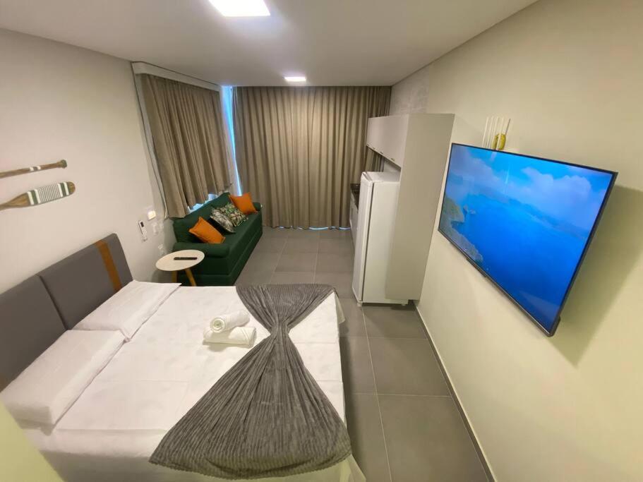 Zimmer mit einem Bett, einem Sofa und einem Kühlschrank in der Unterkunft Nawa Beach Residence by La Playa in Tamandaré