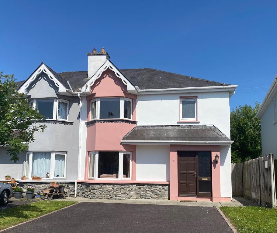 ケンメアにあるConvenient spacious 3 bedroom home in Kenmare townの私道付白ピンクの家