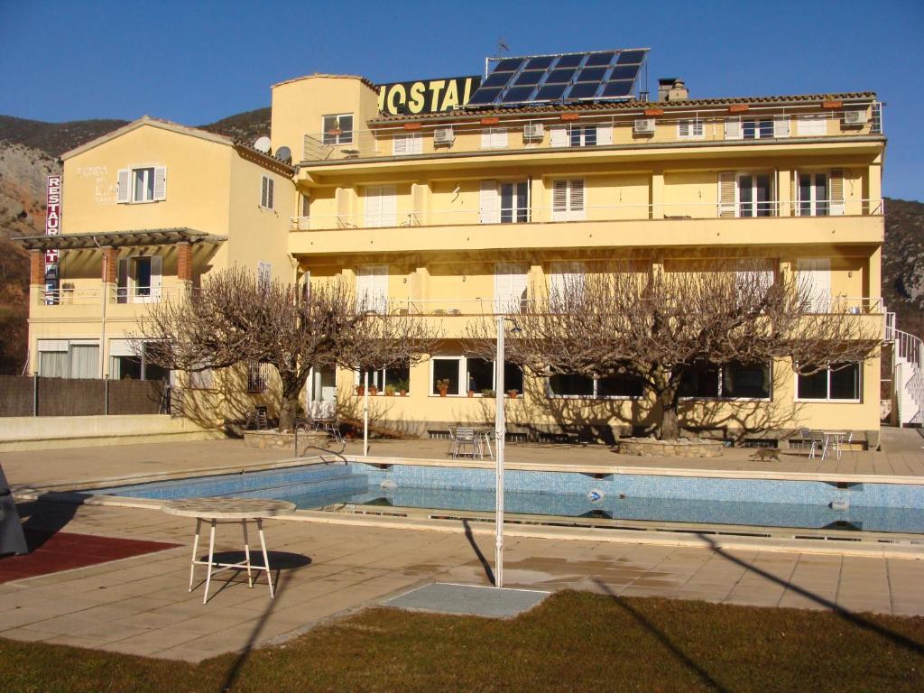 un hotel con piscina frente a un edificio en Hotel Del Llac en Coll de Nargó