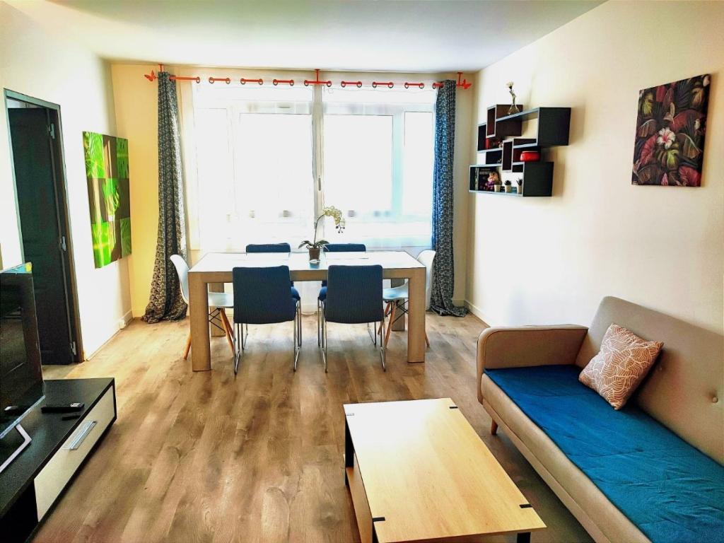 un salon avec une table et un canapé dans l'établissement appartement spacieux 3 chambres, à Savigny-sur-Orge