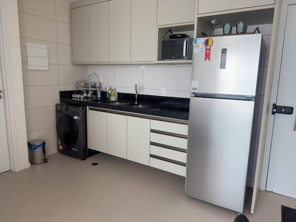 eine weiße Küche mit einem Kühlschrank und einem Geschirrspüler in der Unterkunft Apartamento em Recife, condomínio de luxo in Recife