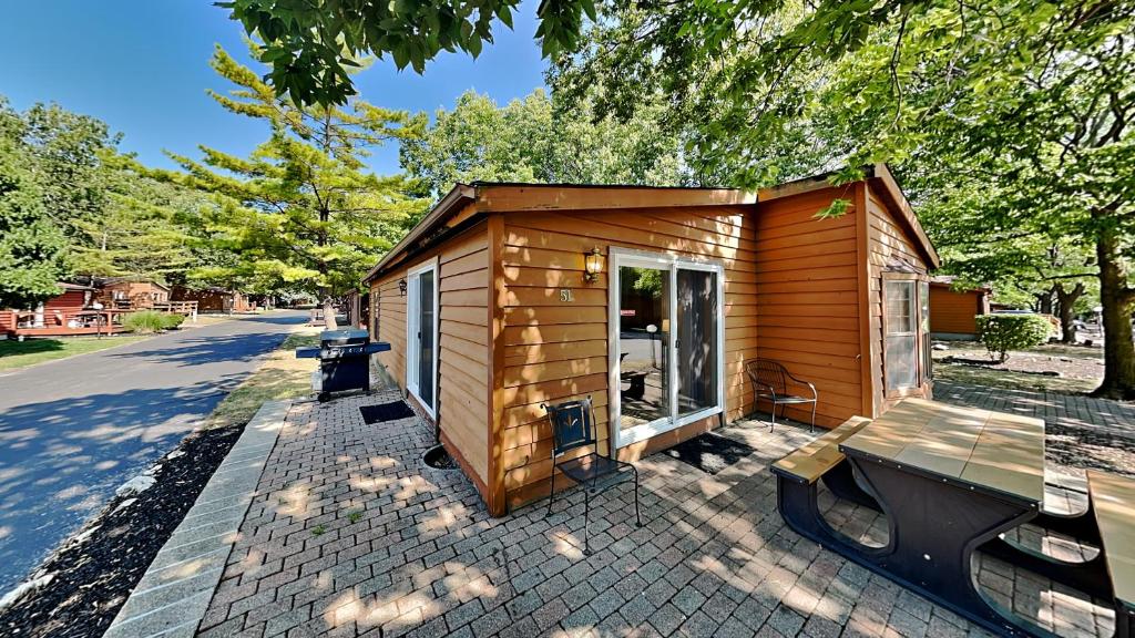 a small wooden cabin with a bench next to a street at Put-in-Bay Island Club #51 in Put-in-Bay