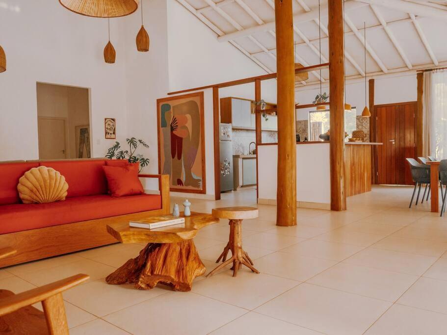 a living room with a red couch and a table at Casa Caetano - Peninsula de Maraú - Taipus de Fora in Taipu
