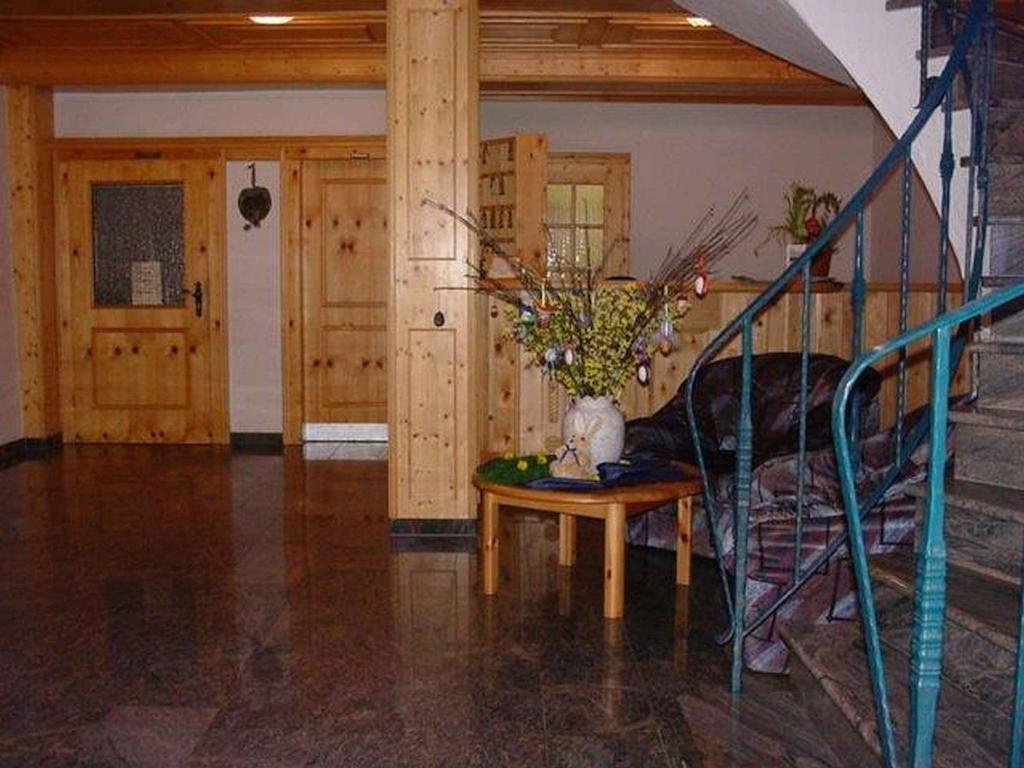 ein Zimmer mit einer Treppe und einem Tisch mit einer Blumenvase in der Unterkunft Gasthof Zum Schützen in Oberprechtal