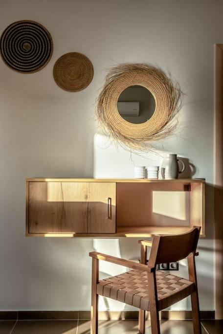 a wooden table with a chair and a mirror at Coco-Mat Efterpi House by Plakias Suites in Plakias