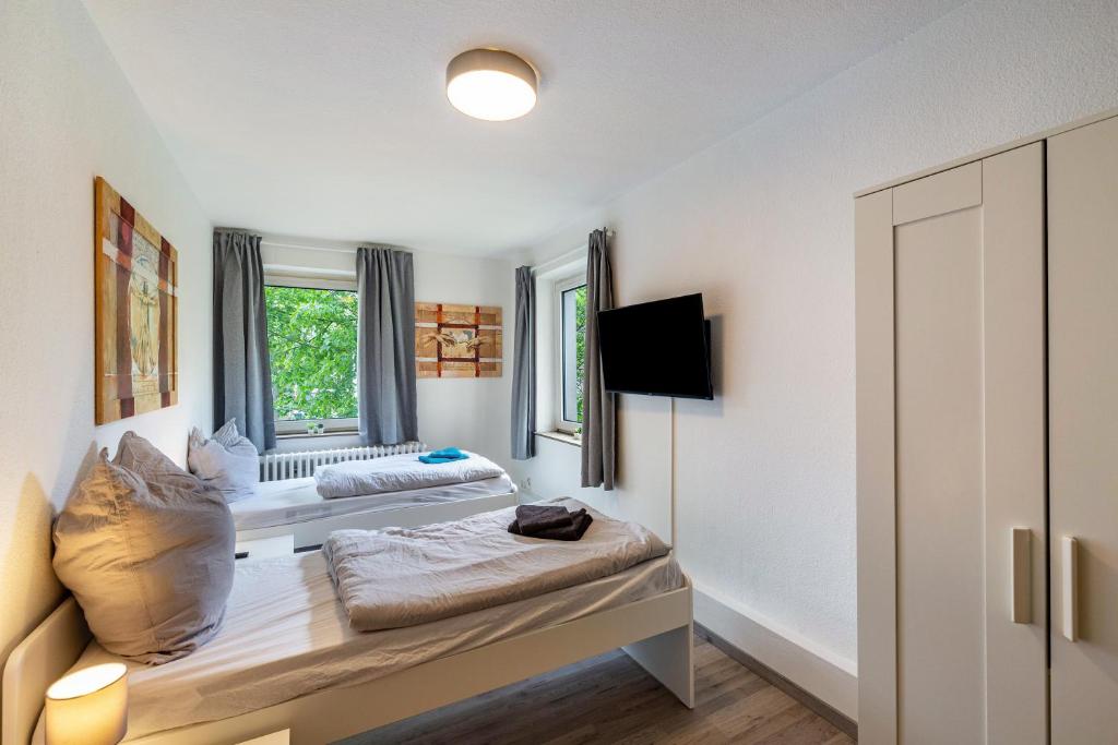 a room with two beds and a window at Urbanes Nest, ideal für Entdecker in Dinslaken