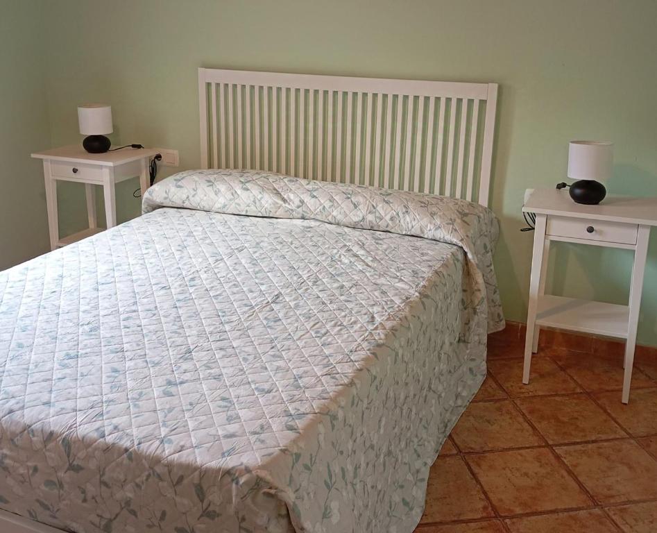 a bedroom with a bed and two night stands at Ca L'Aida Rural 2 in Montblanc