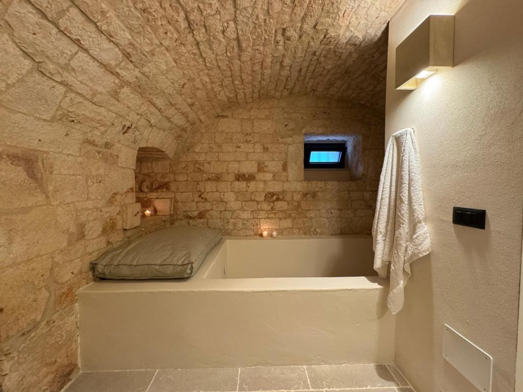 a bathroom with a bath tub in a stone wall at Masseria Ramasian in Monopoli