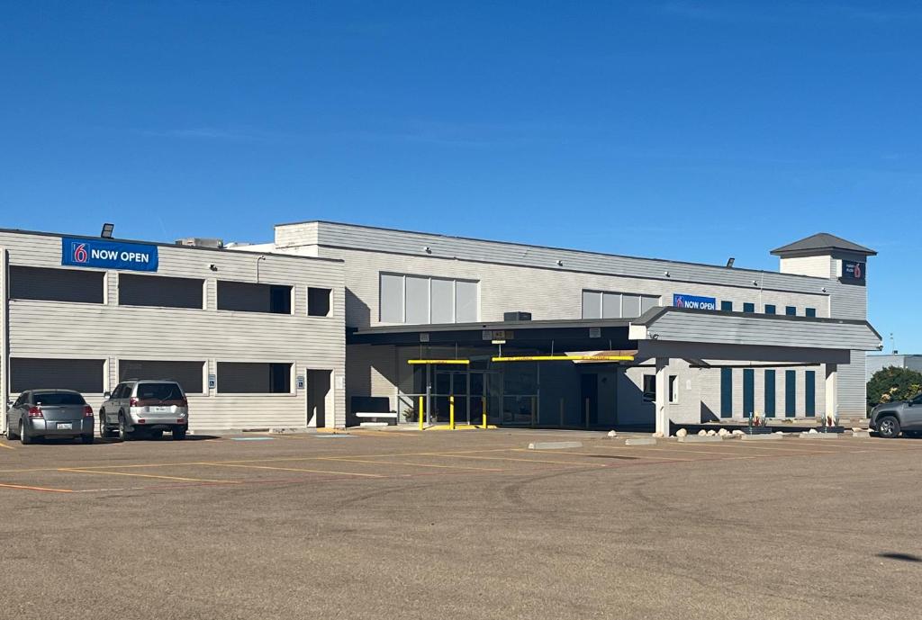 a large building with cars parked in a parking lot at Studio 6 Dumas, TX in Dumas