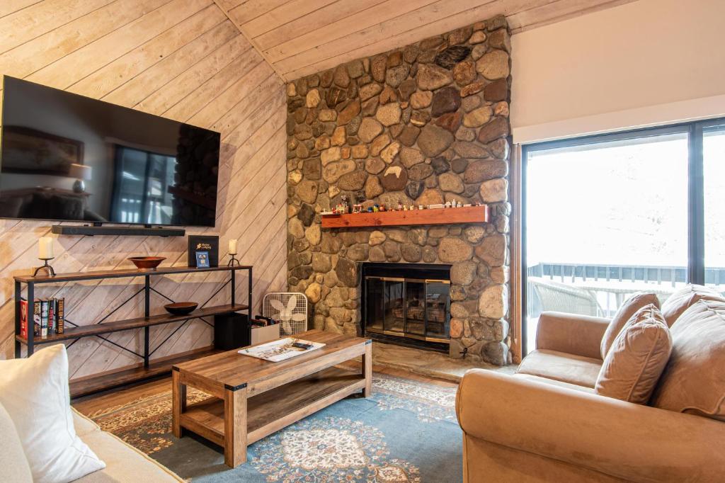 a living room with a stone fireplace and a couch at Fairway Nine Condo 4322 in Sun Valley