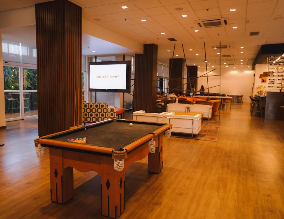 a pool table in a room with a screen at ibis Recife Boa Viagem in Recife