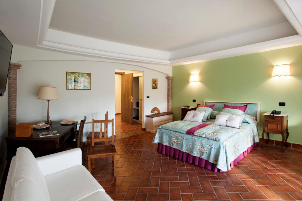 ein Schlafzimmer mit einem Bett und ein Wohnzimmer in der Unterkunft La Vignola Country Hotel in Ceprano