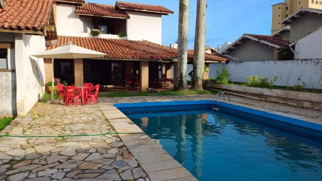 una casa con piscina delante de una casa en Jardim Aruan, Caraguatatuba ,sp, en Caraguatatuba