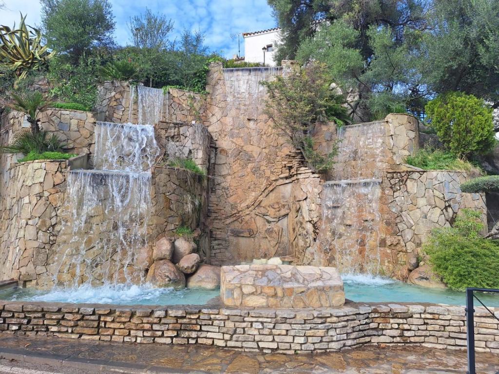 a stone retaining wall with a waterfall in a yard at El Rinconcito Mágico in El Bosque