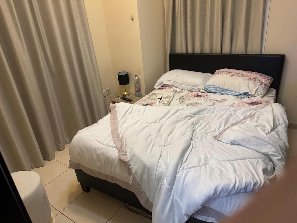 an unmade bed in a room with a window at 1BHK Furnished Apartment in Dubai