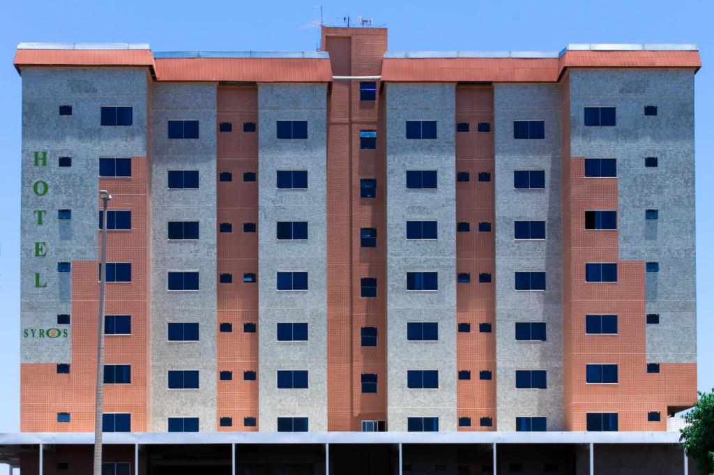 un edificio alto con muchas ventanas. en Syros Hotel, en Gama