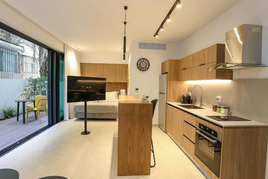 a kitchen with a sink and a bed in a room at Luxury Garden Studio Apartment 2 in Tel Aviv