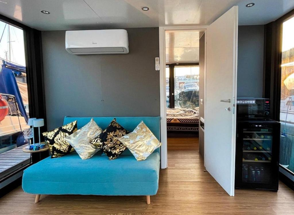 多尔梅莱托HouseBoat - Lago Maggiore con Jacuzzi的客房内的蓝色沙发上配有枕头
