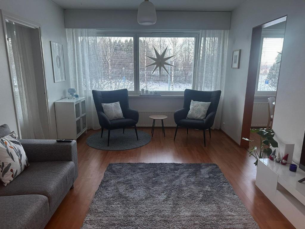 a living room with a couch and two chairs and a window at Finngland I in Rovaniemi