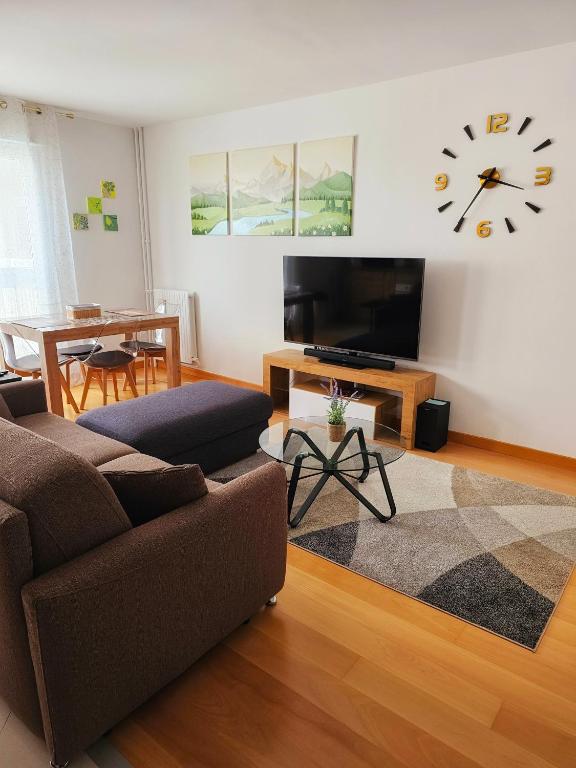 un salon avec un canapé et une horloge au mur dans l'établissement Renewed Spacious 35m2 Studio in Paris, à Paris