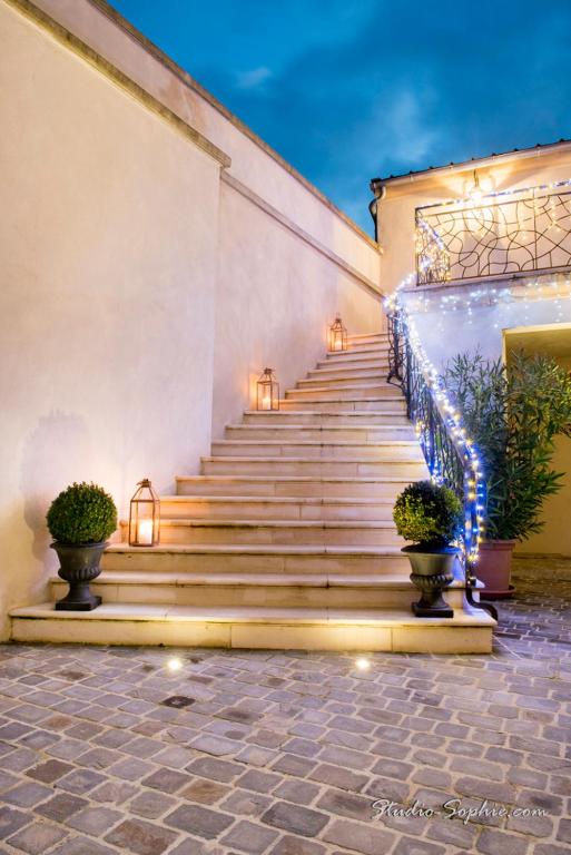 a staircase with lights and potted plants in front of a building at Champagne Domaine Sacret - AY in Épernay