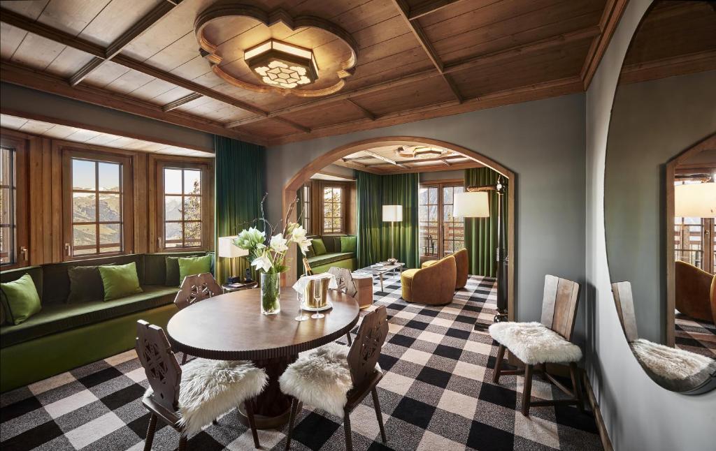 a living room with a table and chairs and a couch at Apogée Courchevel, Oetker Hotels in Courchevel
