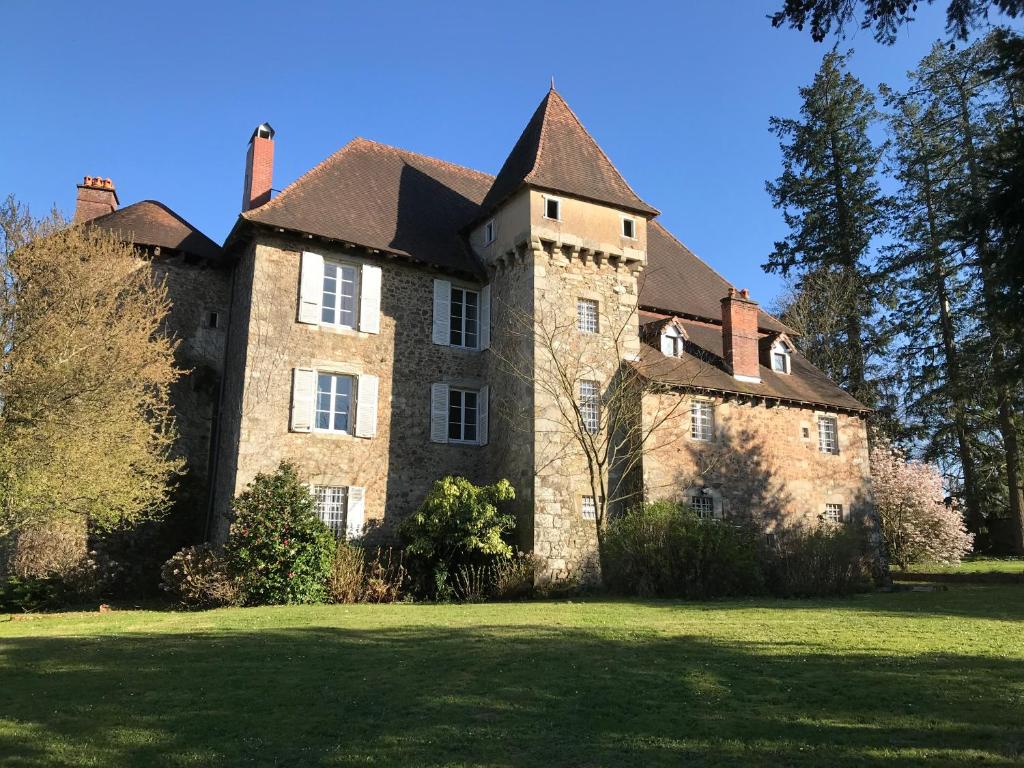 un gran edificio de ladrillo con techo en un campo de césped en Chateau de Grand Bonnefont, en Limoges