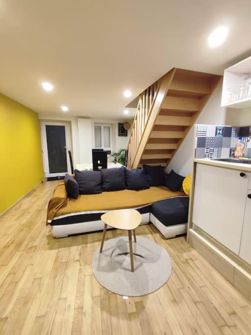 un salon avec un canapé et un escalier dans l'établissement logement près des volcans, à Durtol