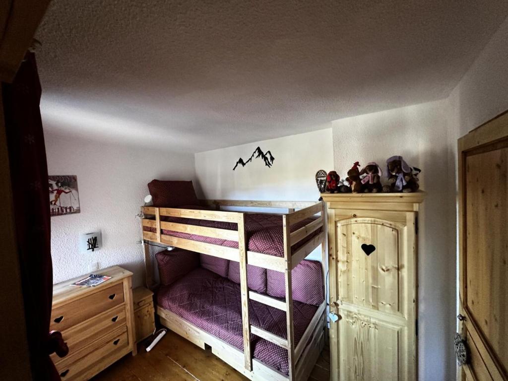 - une petite chambre avec des lits superposés et des draps violets dans l'établissement Résidence Croix Du Sud - 3 Pièces pour 7 Personnes 551, à Aime La Plagne
