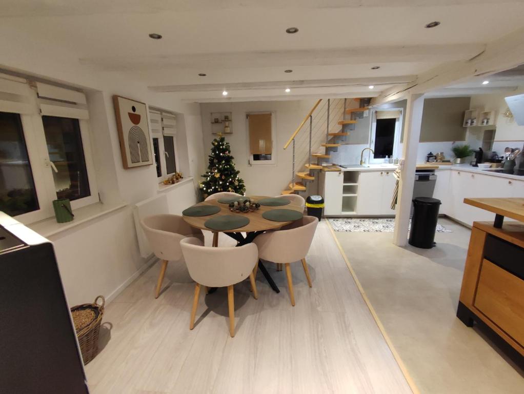 a kitchen with a table and chairs and a christmas tree at Charmante maison alsacienne, sauna et jardin in Châtenois