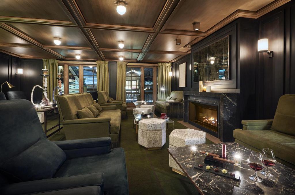 a living room with a couch and a fireplace at Apogée Courchevel, Oetker Hotels in Courchevel