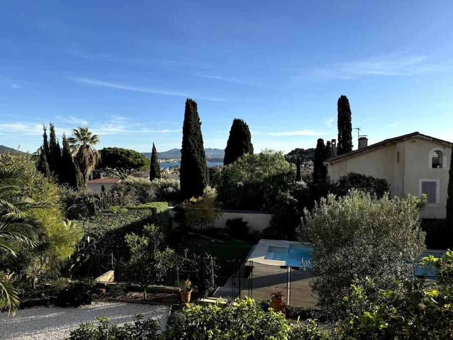 Elle offre une vue sur un jardin avec des arbres et une maison. dans l'établissement Le petit Paradis - vue mer - Piscine, à Sanary-sur-Mer