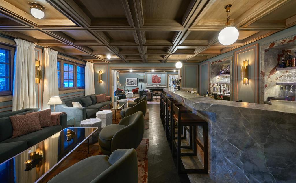 a bar with a bunch of chairs and a counter at Apogée Courchevel, Oetker Hotels in Courchevel
