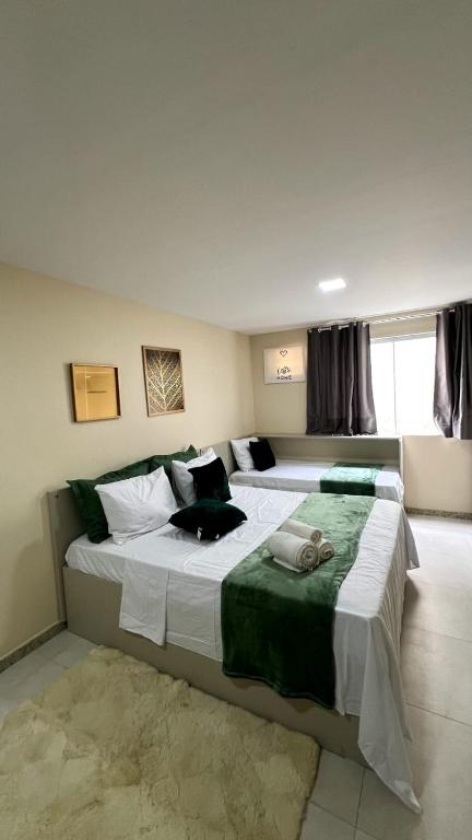 a bedroom with two beds and a window at Lofts HOME Cabo Frio in Cabo Frio