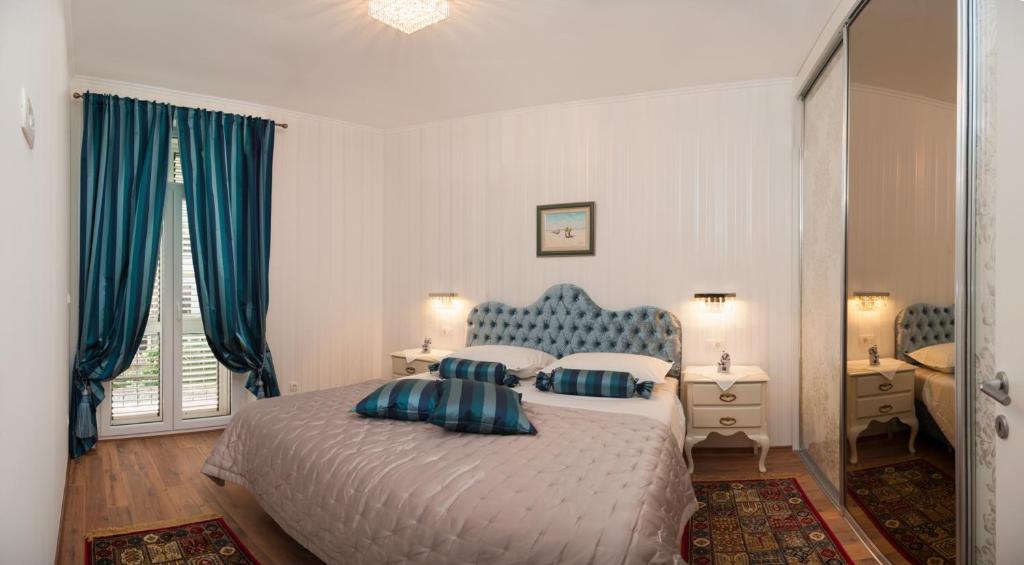 una camera da letto con un letto con cuscini blu e bianchi di Apartments Tonis a Spalato (Split)