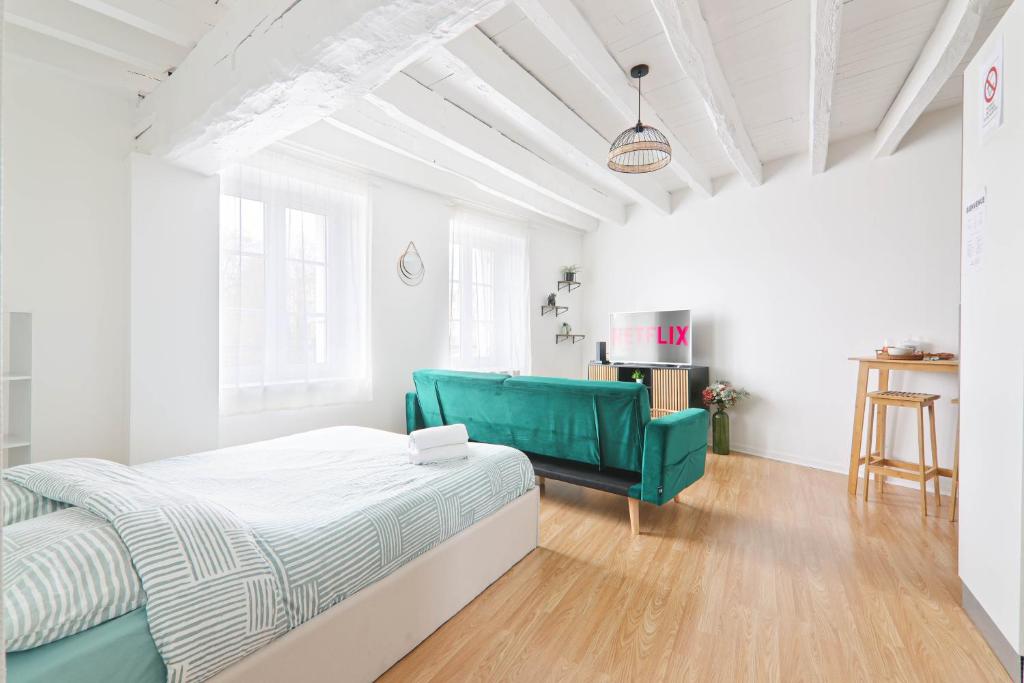 a bedroom with a bed and a green couch at Retraite Romantique à Étampes in Étampes