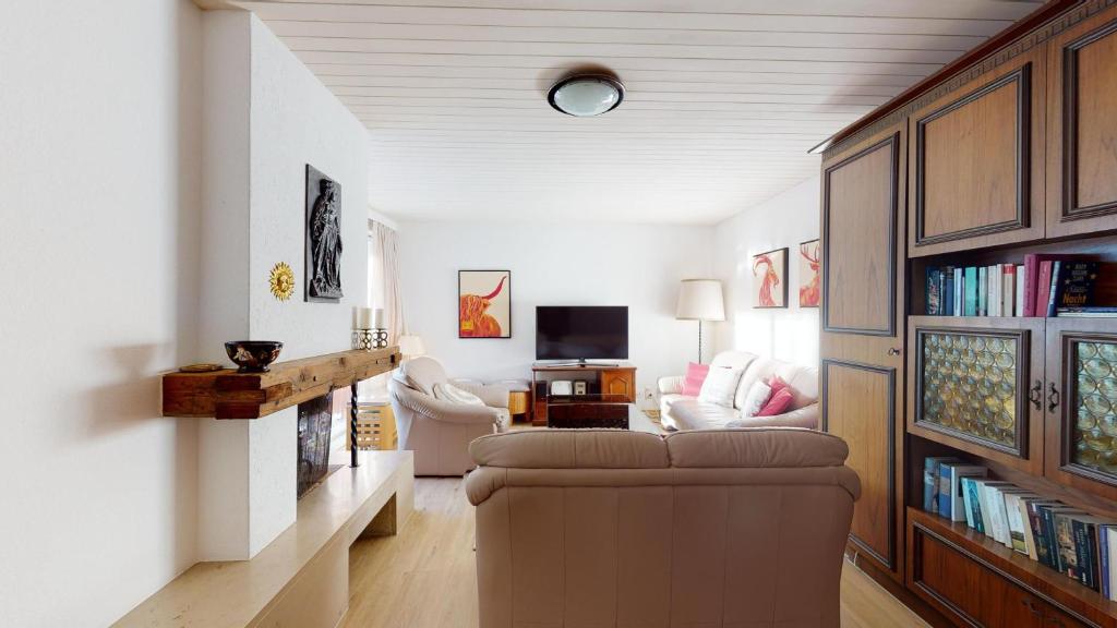 a living room with a couch and a tv at Apartment Skyline 307 in St. Moritz