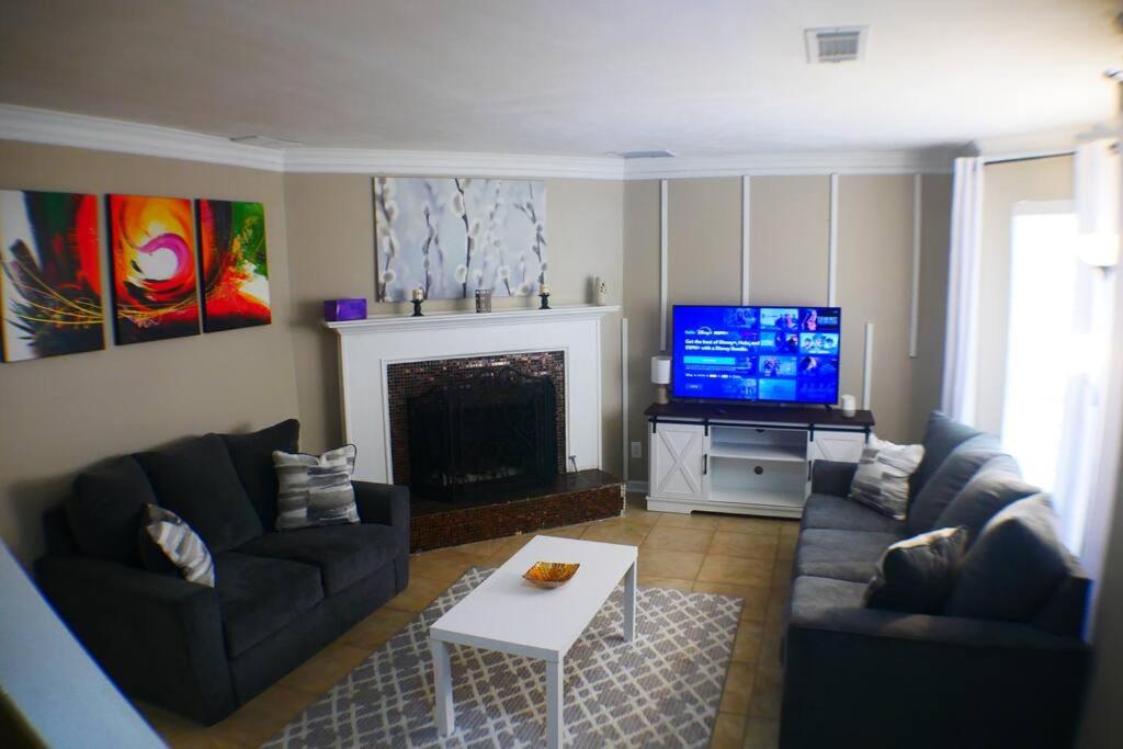 a living room with a fireplace and a tv at The Trace Elegant Eclectic Home with patio in Smyrna Ga in Smyrna