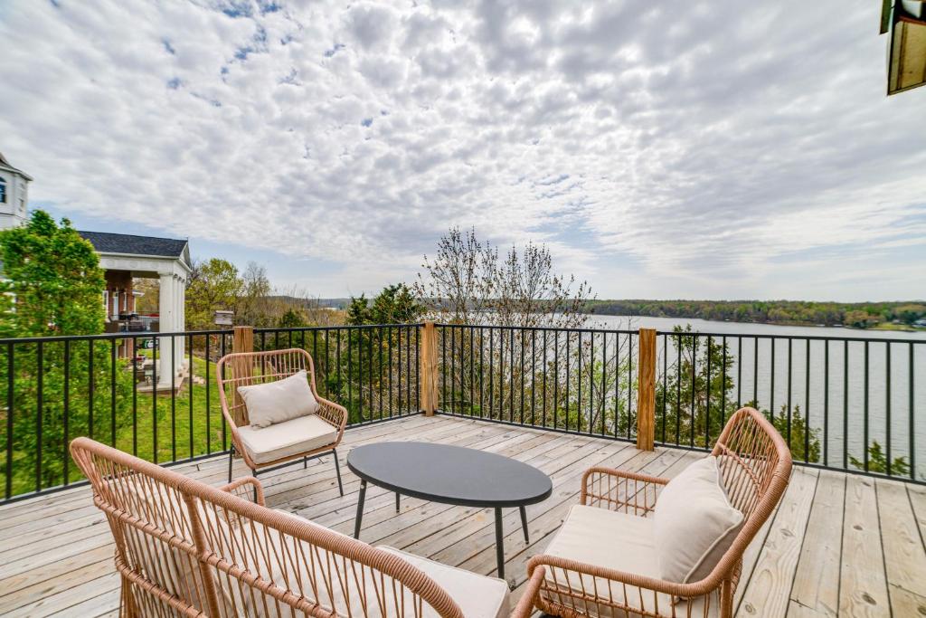 a deck with chairs and a table and a view of the water at Deck with Lake Barkley Views Spacious Family Home! in Eddyville
