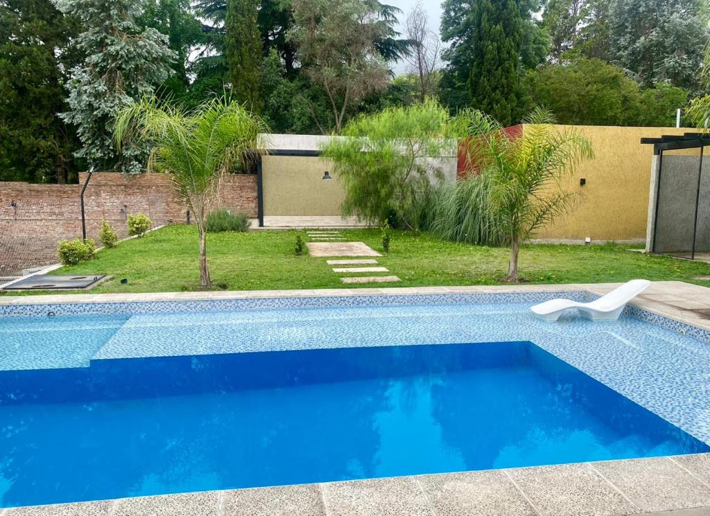 ein blauer Pool in einem Hof mit einem Haus in der Unterkunft Magdalena in Santa Rosa de Calamuchita