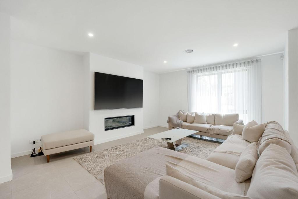 a white living room with a couch and a fireplace at Inlet Paradise in Rhyll