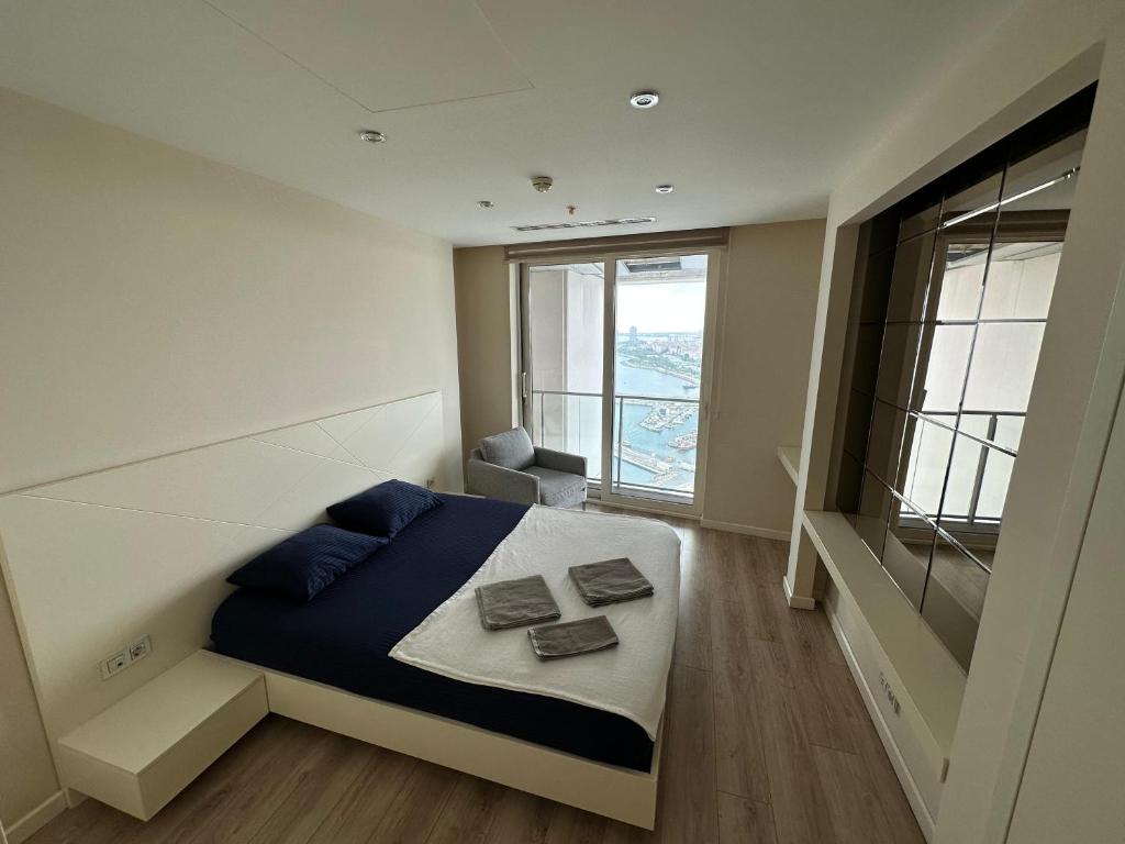 Un dormitorio con una cama y una ventana grande. en Ottomare Suites sea, view, pool, gym, en Estambul