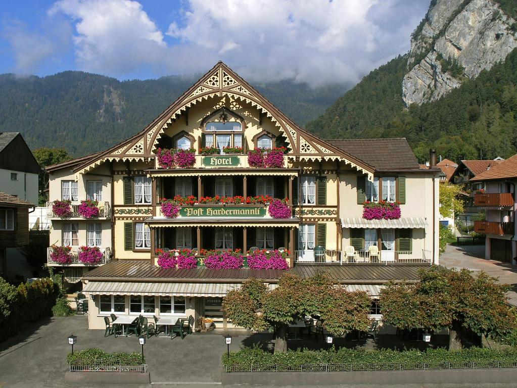 un grand bâtiment avec beaucoup de fleurs sur lui dans l'établissement Post Hardermannli, à Interlaken