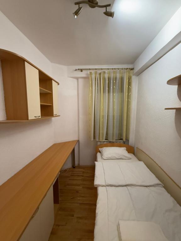 a room with two beds in it with a window at City Square Apartment 1st floor in Strumica