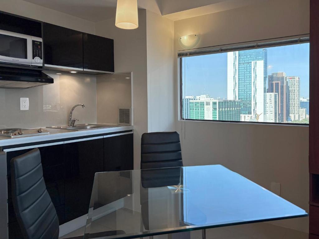 A compact suite kitchen and dining area with a city-facing window.